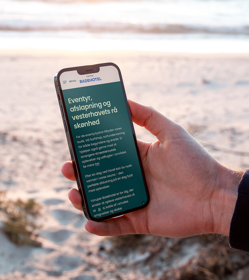 The new website on a phone, on the beach